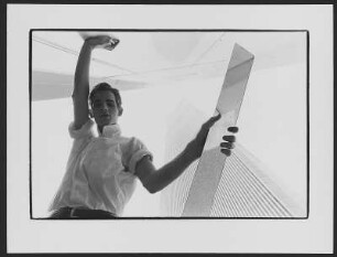 Skyscraper : Junger Mann in weißem Hemd zwischen New Yorker Hochhäusern, ein spiegelndes Blech in der Hand