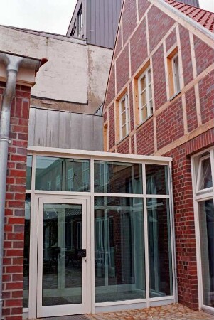 Mühlenstraße 21: giebelständiges Wohn- und Geschäftshaus: nach Sanierung: rückwärtige Giebelseite mit Fachwerk, Verbindungsgang aus Glas mit Tür, links rückwärtiges Gebäude [angeschnitten]: hinten Kaufhaus Nickel [angeschnitten]