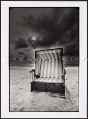 Blick auf einen Strandkorb mit dunklen Wolken am Himmel (Altersgruppe 18-21)