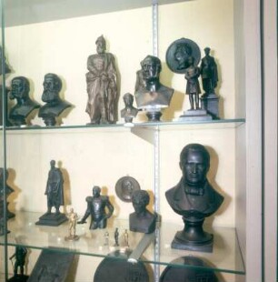 Hirzenhain. Eisen-Kunstguß-Museum. Vitrine mit Büsten, Statuetten und Medaillons