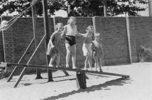 Betriebskindergarten der VEB Stralauer Glaswerke : Kinder auf einem Spielplatz auf einer Wippe