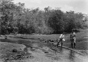 Kleiner Bach : Zwei Mitglieder der Expedition an einem Bach stehend, rechts Professor Paul Vageler.