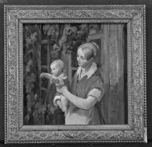 Frau mit Kind vor weinlaubumrankter Hauswand