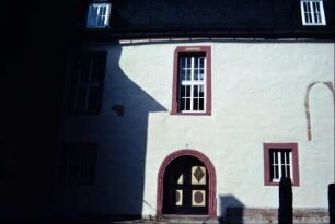 Traufseite der Kirche mit Eingangsbereich; vermauertes Fenster