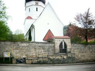 Ansicht von Westen mit Kirche (Romanisch-Langhaus und achteckige Glockenstube 1840 neu erbaut) über Kirchhofmauer und erhaltenem äußerem Torbogen (Wehrgang sowie Toranlage im 19 Jh abgetragen)