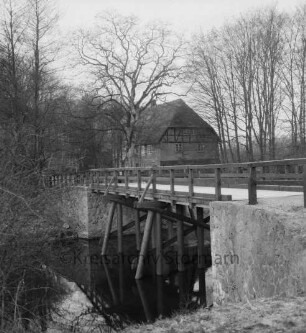 Friedensbrücke: vorn links Trave: dahinter Nütschauer Mühle und Bäume
