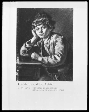 An einem Tisch sitzender Hirtenbub mit Pelzkappe