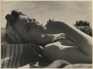 Frau liegt am Strand