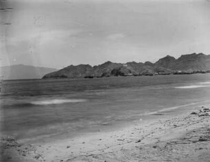 Strand von Mindelo : Blick vom Strand in Mindelo auf das Meer. Im Hintergrund der Hafen und die Insel Santo Antão(links).