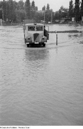 LKW, durch das überschwemmte Ausstellungsgelände fahrend