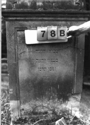 Grabstein 78 (Index: 100110806) Material: Sandstein Zustand: Giebel beschädigt, Abschieferungen an den unteren Ecken Maße HxBxT: 148x69x21 cm Beschreibung: Stele, Rundbogenabschluß mit Verdachung und Rundbogenfries, Schriftfelder eingetieft: Grabstein 78B