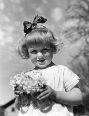 Kinderbilder. Kleines Mädchen mit Blumenstrauß