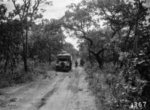 Unterwegs : Ein Lastkraftwagen der Expedition auf einer Sandstraße. Im Hintergrund sind einige Männer, einer rennt zum LKW.