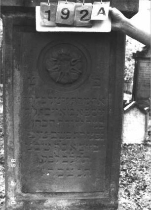 Grabstein 192 (Index: 99609828) Material: Sandstein Zustand: verwittert Maße HxBxT: 191x71x26 cm Beschreibung: Stele, spitzer Giebel, Seitenakrotere, Schriftfeld rechteckig begrenzt, Sockel Symbolik: Rosette: Grabstein 192A