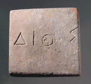 Einstufiges quadratisches Gewicht (äginetischer Standard) mit griechischer Inschrift (ΔΙΟΣ)