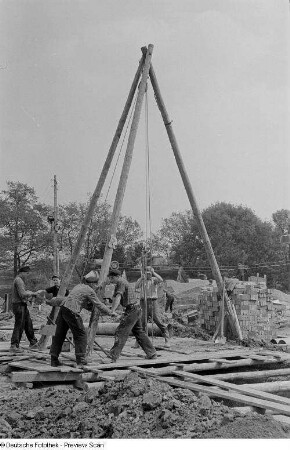 Maurer bei der Arbeit auf der Baustelle Straße der III. Weltfestspiele (heute: Ranstädter Steinweg)