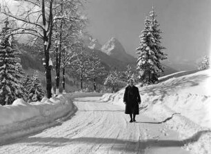 Österreich. Tirol. Mieminger Gebirge. Spaziergänger auf einer Straße bei Ehrwald. Ansicht aus dem Gaistal mit Sonnenspitze (rechts) und Wampeter Schrofen (links)