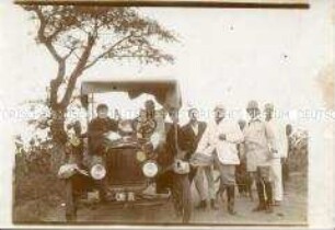 Gruppenbild europäischer Siedler in Angola neben einem Automobil