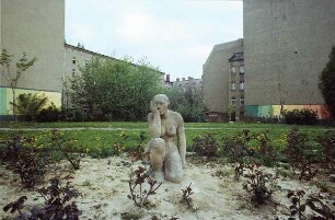 DDR. Neubaugebiet. Grünfläche mit Freiplastik einer niederknienden Frau