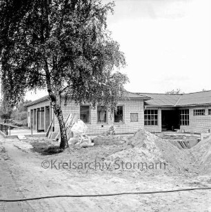 Sporteinrichtungen: Sportanlage am Kortenkamp: Sportlerheim: Sportverein (SV) Großhansdorf von 1942 e. V.: Neubau vor Fertigstellung: davor Handwerker: vorn Sandhaufen und Baumaterial: links Baum