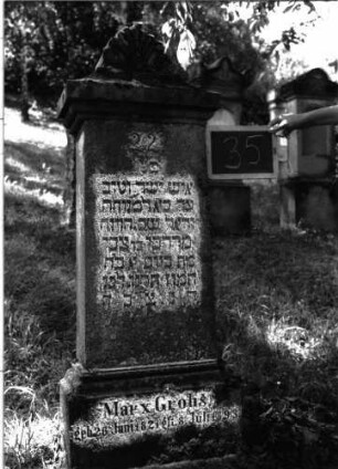 Grabstein 35 (Index: 100100954) Material: Kalkstein Zustand: verwittert Maße HxBxT: 140x43x20 cm Beschreibung: Stele, Sockel, Abdeckplatte mit Palmettenaufsatz Symbolik: Palmette Besonderheit: eingemeißelte Nummer: 22: Grabstein 35
