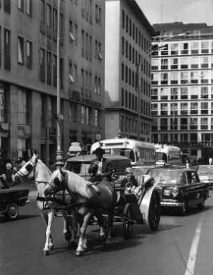 Straßenbild mit Pferdefuhrwerk, Bus und Taxi