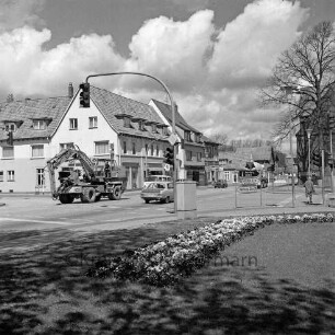 Große Straße / B 75: Blick von der östlichen Freifläche auf Kreuzung, nach links Abzweig Fritz-Reuter-Straße, nach rechts Abzweig Straße Woldenhorn: Blumenrabatten, Ampelanlage, Wegweiser nach Hamburg, nach Lübeck, zur Autobahn, zum Freibad: Autos, Baufahrzeug, Fußgänger: im Hintergrund rechts Blick auf Schlosskirche und Gottesbuden