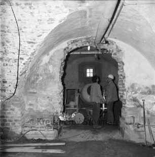 Restaurierung: Kellergewölbe: zwei Arbeiter, Beton-Trommelmischer, Schubkarre: Kellerfenster