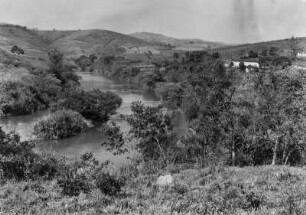 Rio de Peixe : Flusslauf des Rio de Peixe unterhalb von Lindóia mit einer Flussinsel und Bäumen und Grasland am Ufer. Im Hintergrund Hügel.