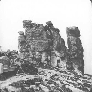 Riesengebirge. Mittagstein (1423 m) mit Steinbank (gestiftet vom R.G.V. [Riesengebirgsverein] Ortsgruppe Breslau 1881-1906) und Wanderer