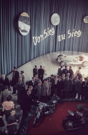 Blick in eine Messelhalle mit Fahrzeugen auf der Mustermesse in Leipzig (1954)
