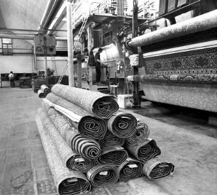 WTF Webstuhl : VEB Wurzener Teppichfabrik. Teppich-Webstuhl. Davor fertige und zusammengerollte Teppiche