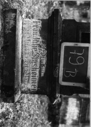 Grabstein 79 (Index: 100090740) Material: Sandstein mit schwarzer Marmorplatte Zustand: vor allem Sock. verwitt/Aufsatz fehlt Maße HxBxT: 183x56x27 cm Beschreibung: getreppt. Sockel, eingezog. Rundbogenabschl. rechteck, . erhöht m. Verdach. , Schrifttafe Symbolik: nach unten hängender Blumenstrauß, Blüten: Grabstein 79B