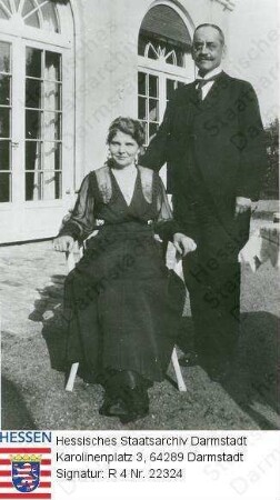 Hochgesand, Wilhelm Dr. jur. (1863-1918) / Porträt mit Ehefrau Maria geb. Mettenheimer (* 1871) auf Rasen vor Haus, er stehend, sie sitzend, Ganzfiguren