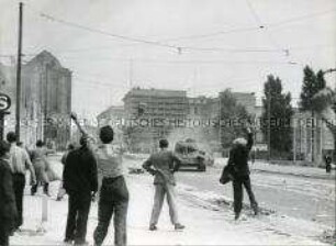 Demonstranten in der Leipziger Straße bewerfen sowjetische Panzer mit Steinen