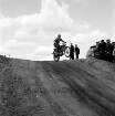 9. Oldesloer Berg-Moto-Cross: Rennstrecke an der Sehmsdorfer Straße [später Travering]: Veranstalter Automobil- und Motorsport Club Stormarn e.V. AMC: Teilnehmer auf Cross-Rad bei Sprung über Berg: oben rechts Streckenposten, Kleinbus, Zuschauer, 29. April 1962
