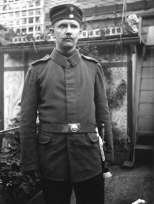 1. Weltkrieg. Portrait eines Soldaten, vor einem Haus stehend