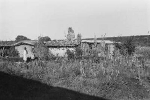 Dorf zwischen Manyoni und Singida : Ein Gehöft zwischen Manyoni und Singida; davor zwei Personen.