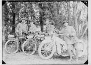 Motorräder; Vier Männer mit drei Motorrädern