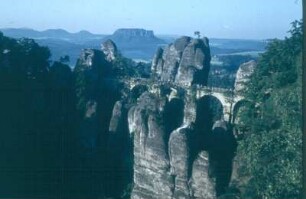 Sächsische Schweiz, Rathener Gebiet. Basteibrücke von der Ferdinandaussicht. Blick nach Südsüdost zum Lilienstein