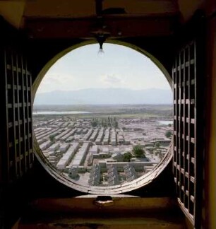 Ausblick auf eine Siedlung durch ein rundes Fenster