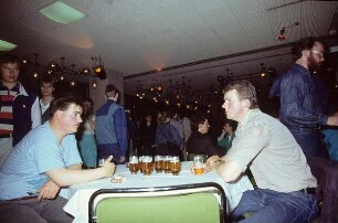 DDR. Zwei junge Männer an einem Biertisch, vielleicht am Rande einer Tanzveranstaltung