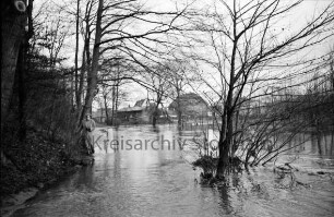 Beste: Kurpark: Hochwasser: Blick von Fußgängerbrücke: vorn Mitte Büsche im Wasser: links Böschung mit Bäumen: hinten Mitte hinter Büschen und Bäumen Gebäude auf Gelände der Papierfabrik und Am Kurpark