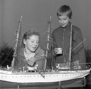 Zwei Kinder beim Bau eines Modellsegelschiffes