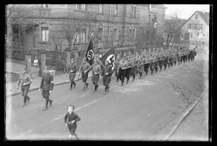 Umzug von Wehrmachtsangehörigen in der Poststraße vor dem Sandsteingebäude des Zahnarztes Dr. Fuchs, sichtbar auch Firma F. Schwender