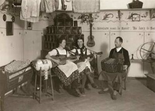 Erzgebirge. Musizierende Klöpplerinnen in einer Hutzenstube in einer Ausstellung