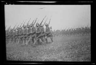 Bei Focșani (Rumänien): 2 Soldatentrupps mit Stahlhelm und geschultertem Bajonett im Stechschritt auf einem weiten Feld (Seitansicht) ("Kaiserparade")