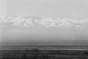 Panorama eines Gebirgszugs : Panorama eines schneebedeckten Gebirgszugs im Tian Shan Hochgebirge. Im Vordergrund eine Ebene