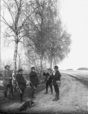 Fünf Jäger beim Umtrunk am Feldrand