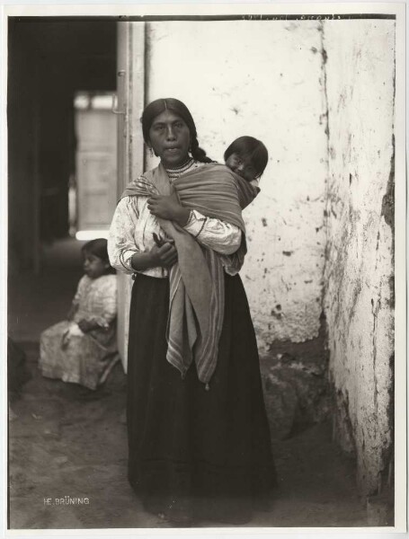 A woman carrying her child on her back